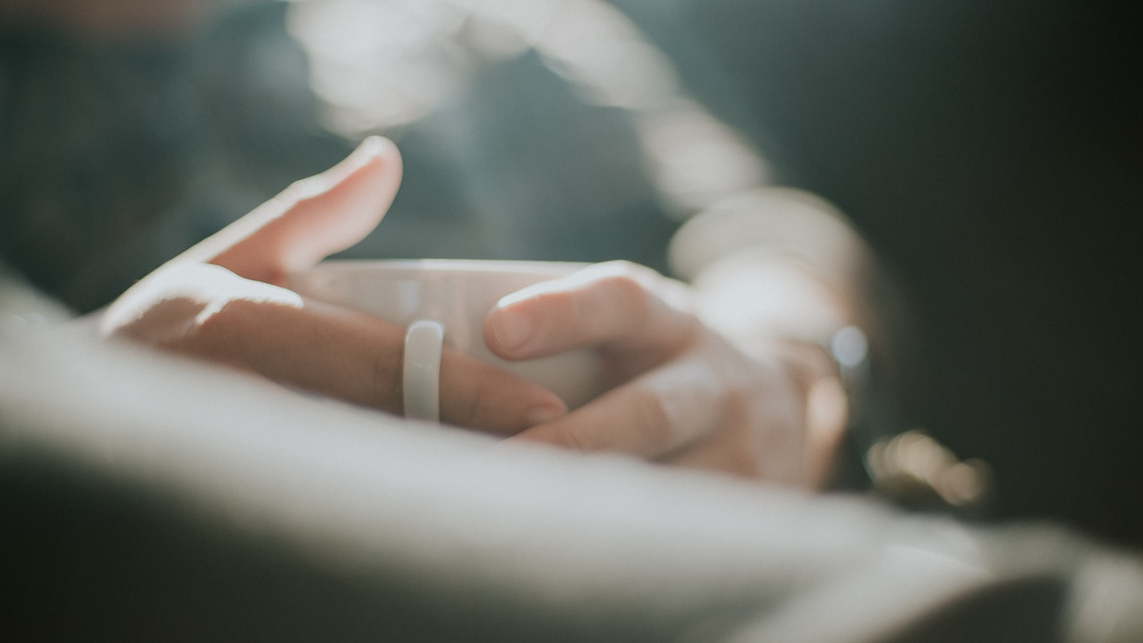 Hands cradling a warm mug in morning light
