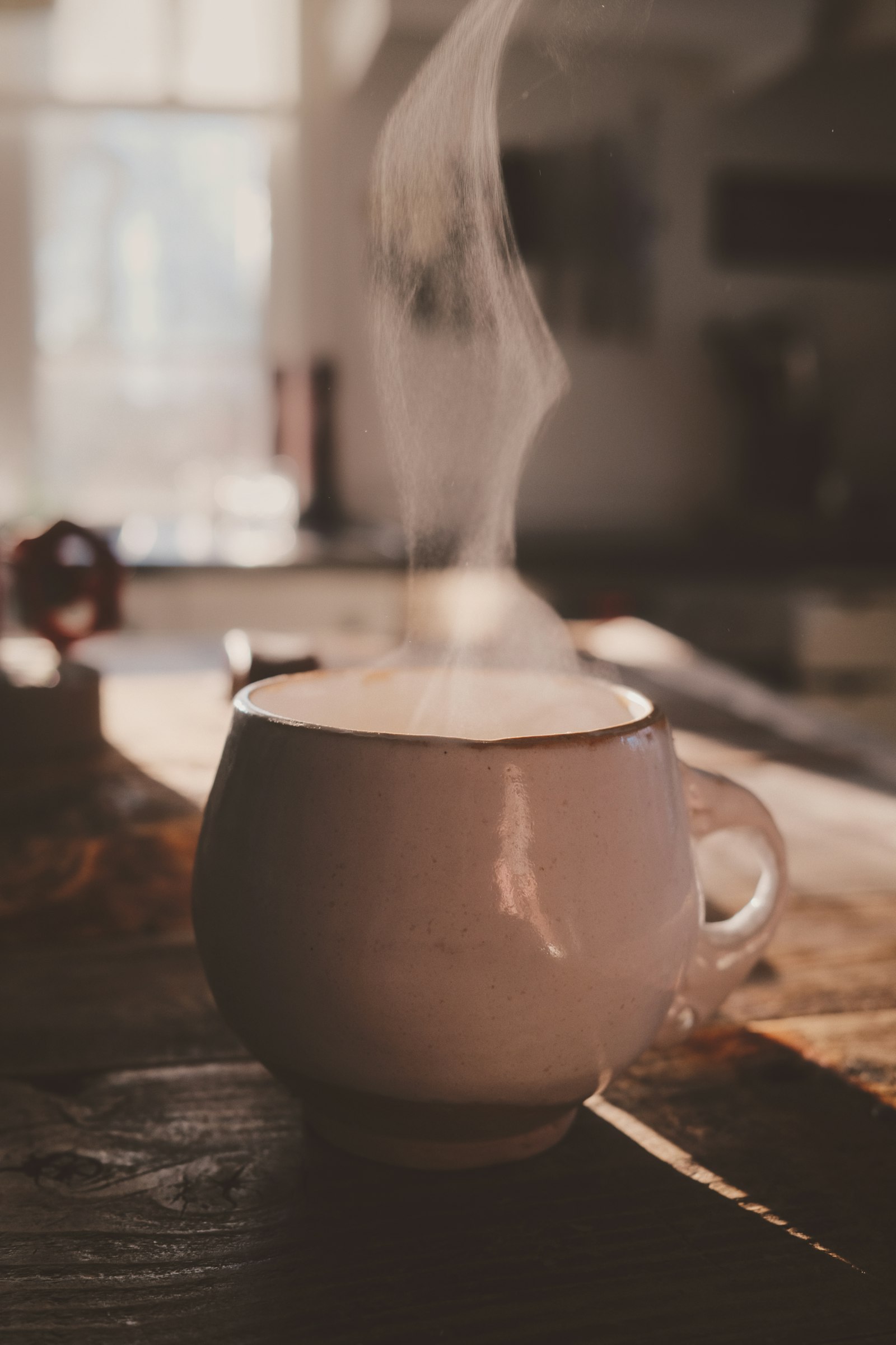 A steaming cup of coffee in warm morning light